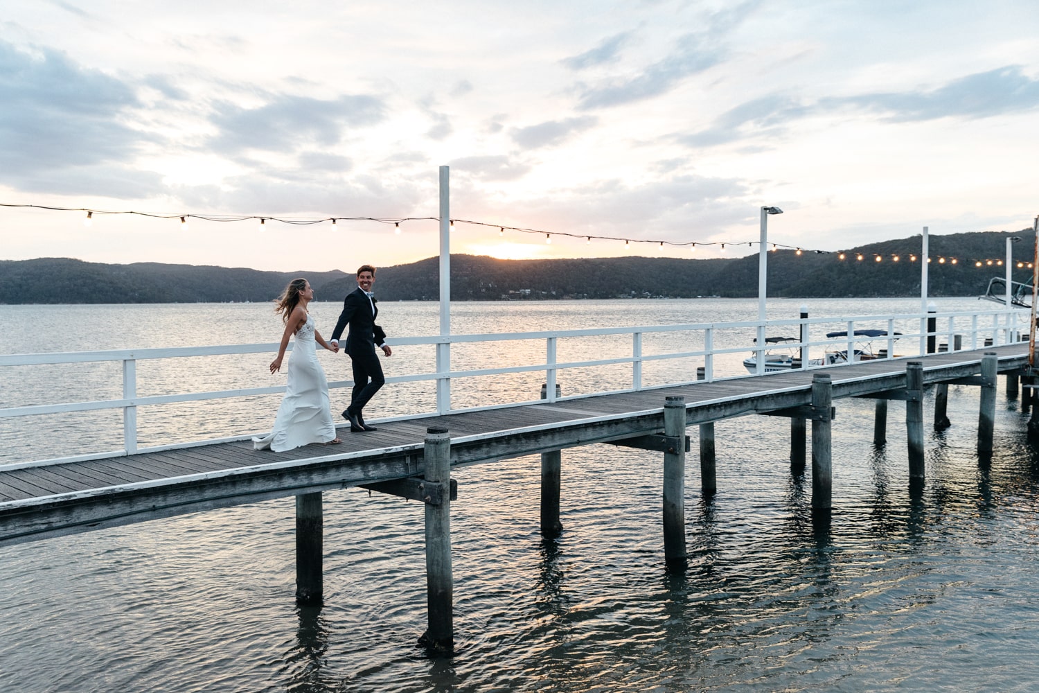 bride and groom holding hands on the jetty - palm beach wedding