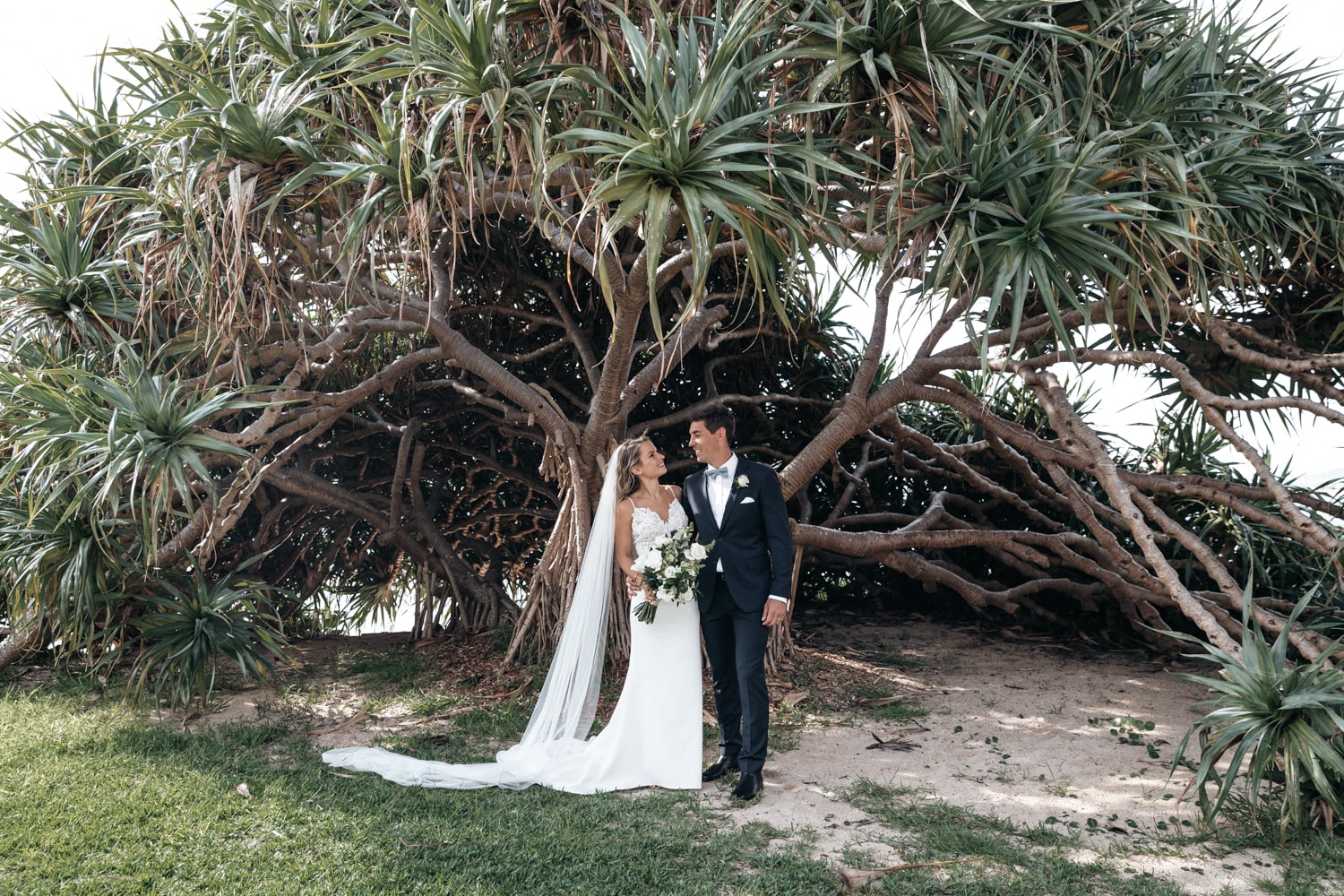 matt and jacqui standing under a tree - palm beach wedding