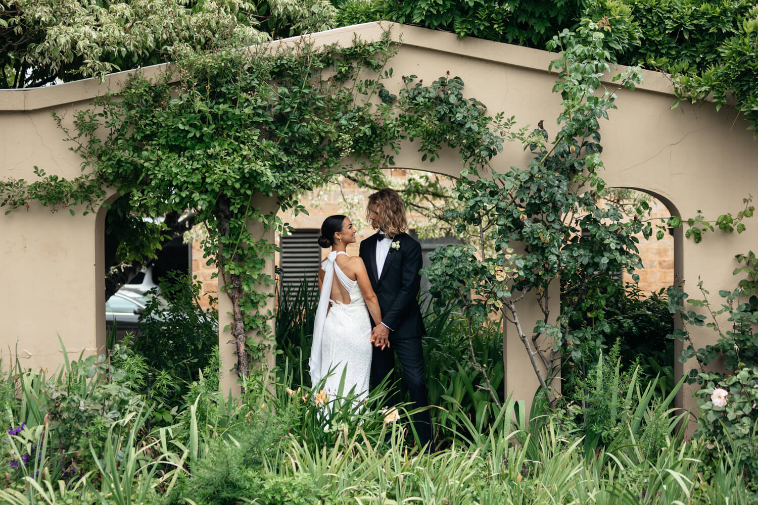 Kelsey and charles standing under an arch at their The Old Coach Stables Wedding