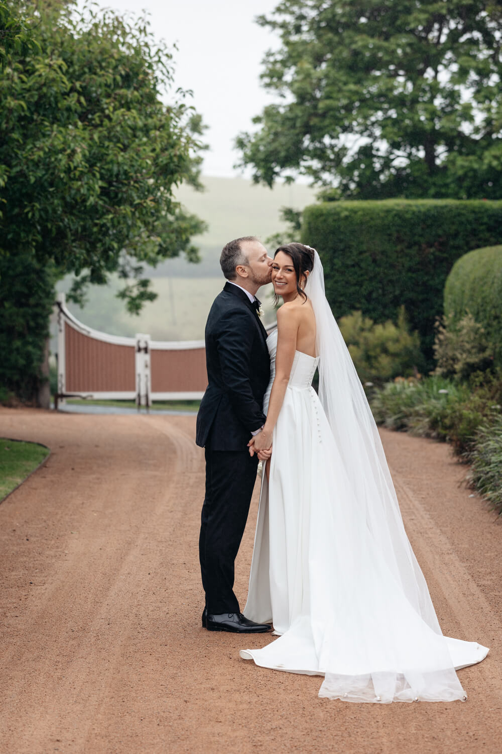 couple kissing on the driveway for their greyleigh kiama wedding