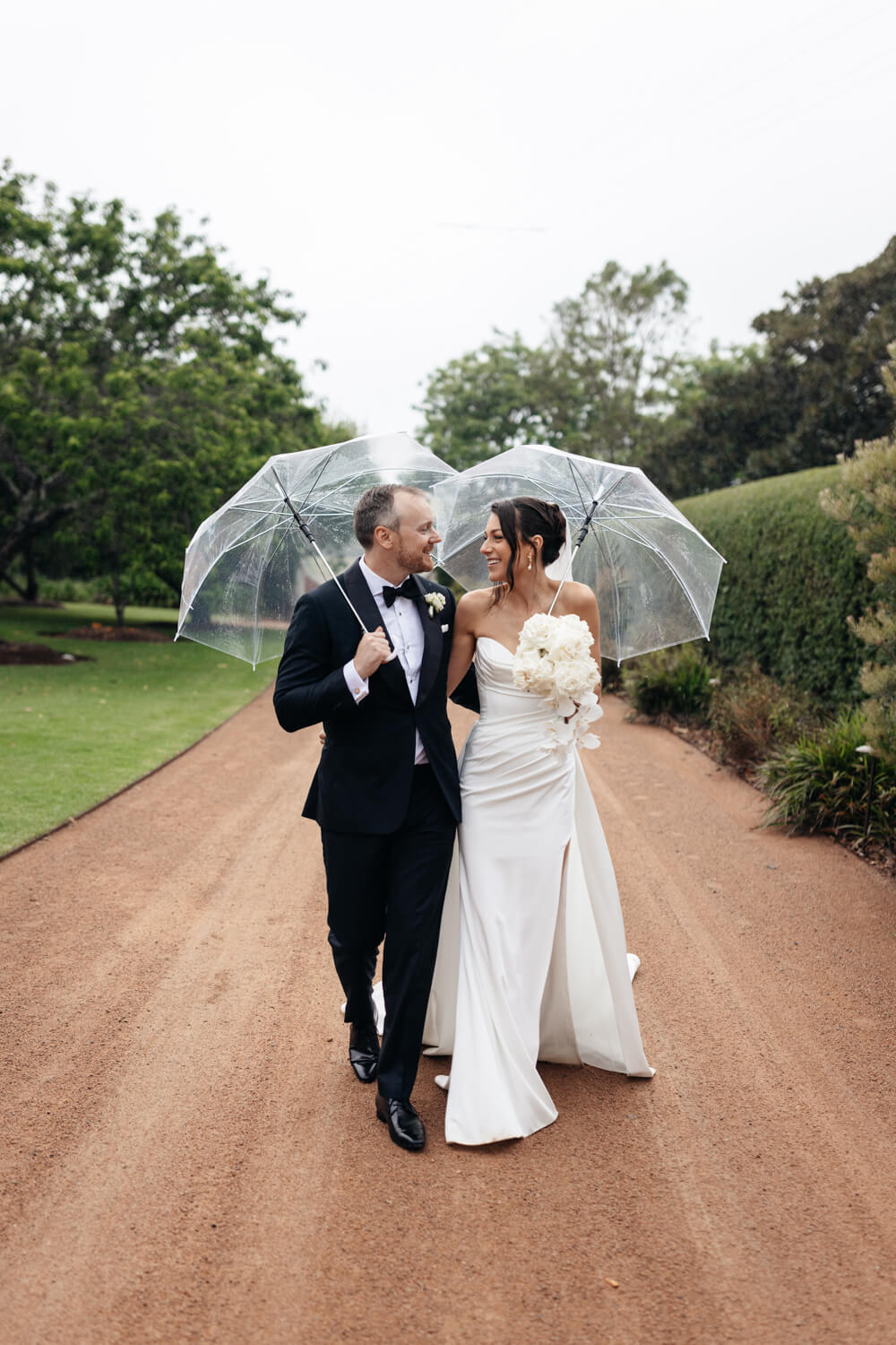 couple walking in the rain at their greyleigh kiama wedding