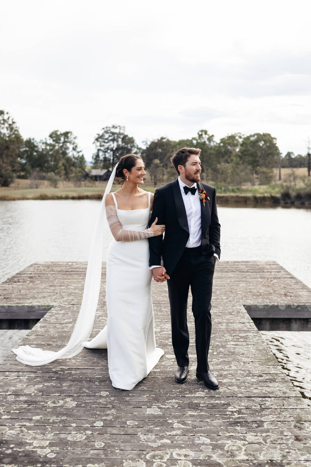 couple walking off the jetty at squire's vineyard