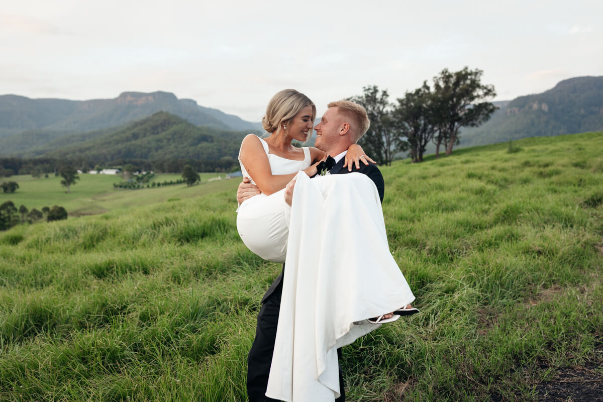 lachlan carrying charlotte at their kangaroo valley wedding