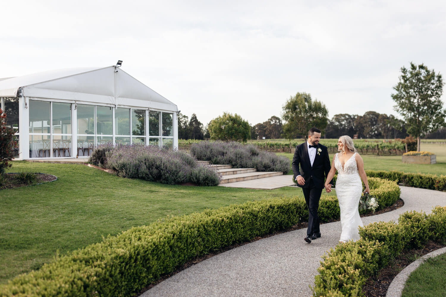 couple walking in front of the reception room at their peterson house wedding