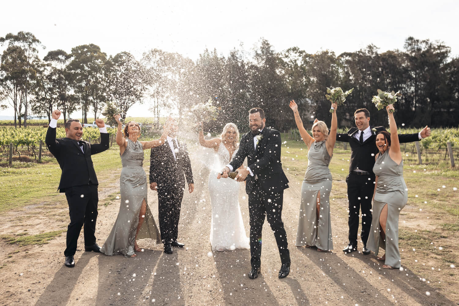 bridal portraits spraying champaigne at their peterson house wedding
