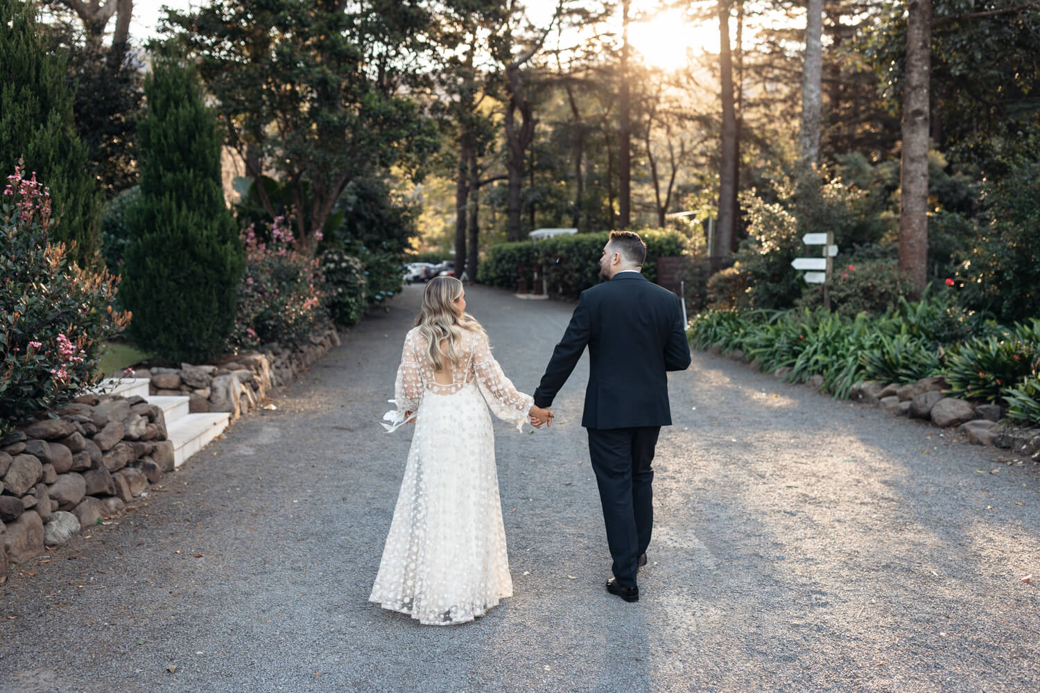 couple walking hand in hand at their lodge Jamberoo wedding