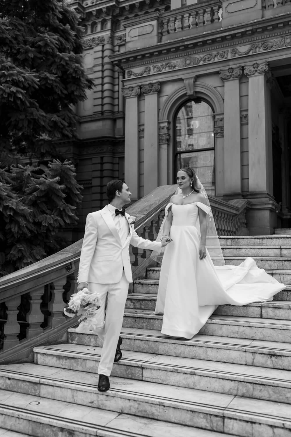 A groom leads his bride down the Town Hall stairs during their Events By Alpha wedding 