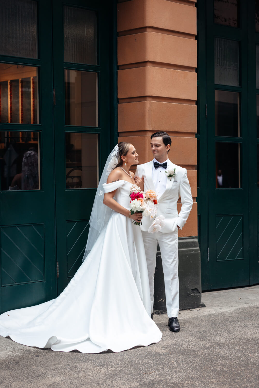 A picture of the bride and groom standing outside Events By Alpha on Castlereigh St