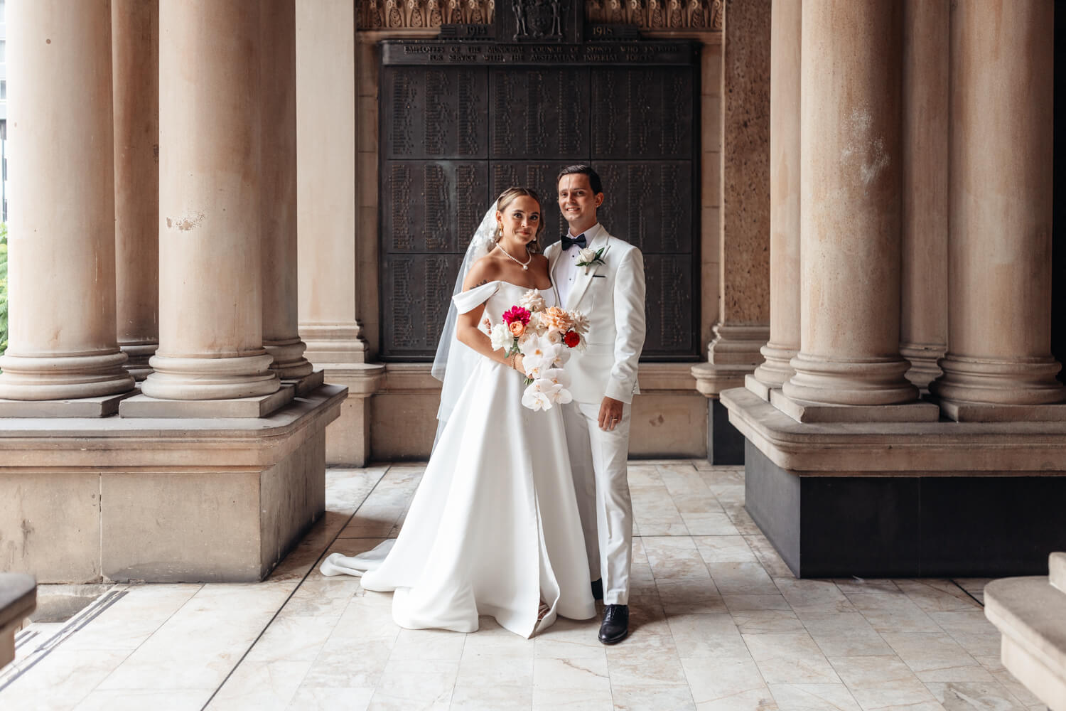 A portrait of the bride and groom smiling at Town Hall in Sydney on their Events By Alpha wedding day