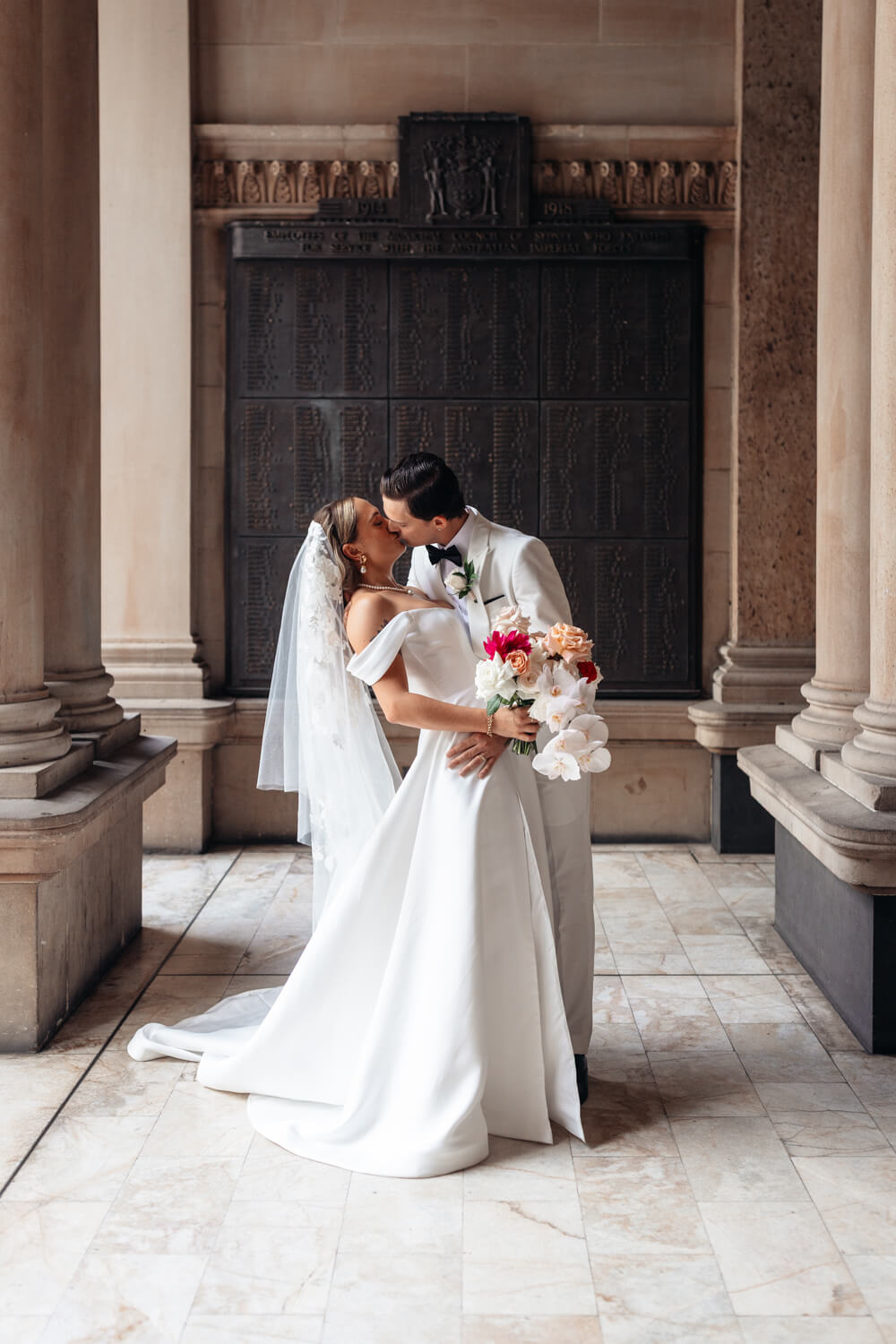 A picture of the bride and groom kissing at Town Hall