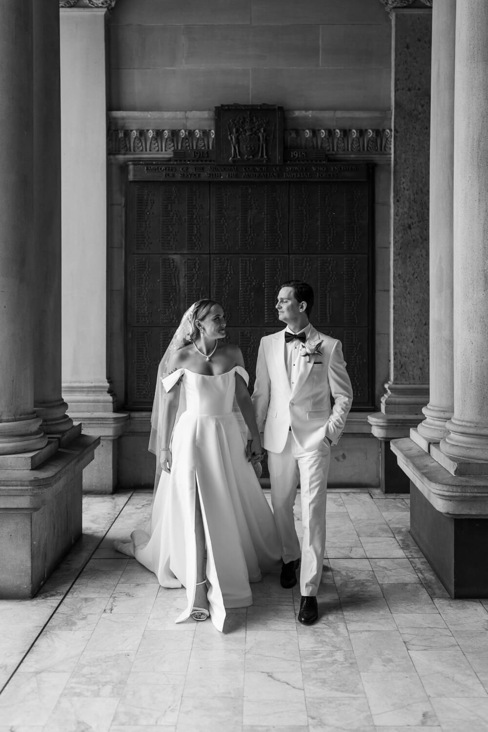 Bride and groom walking hand in hand at Town Hall Sydney on their wedding day
