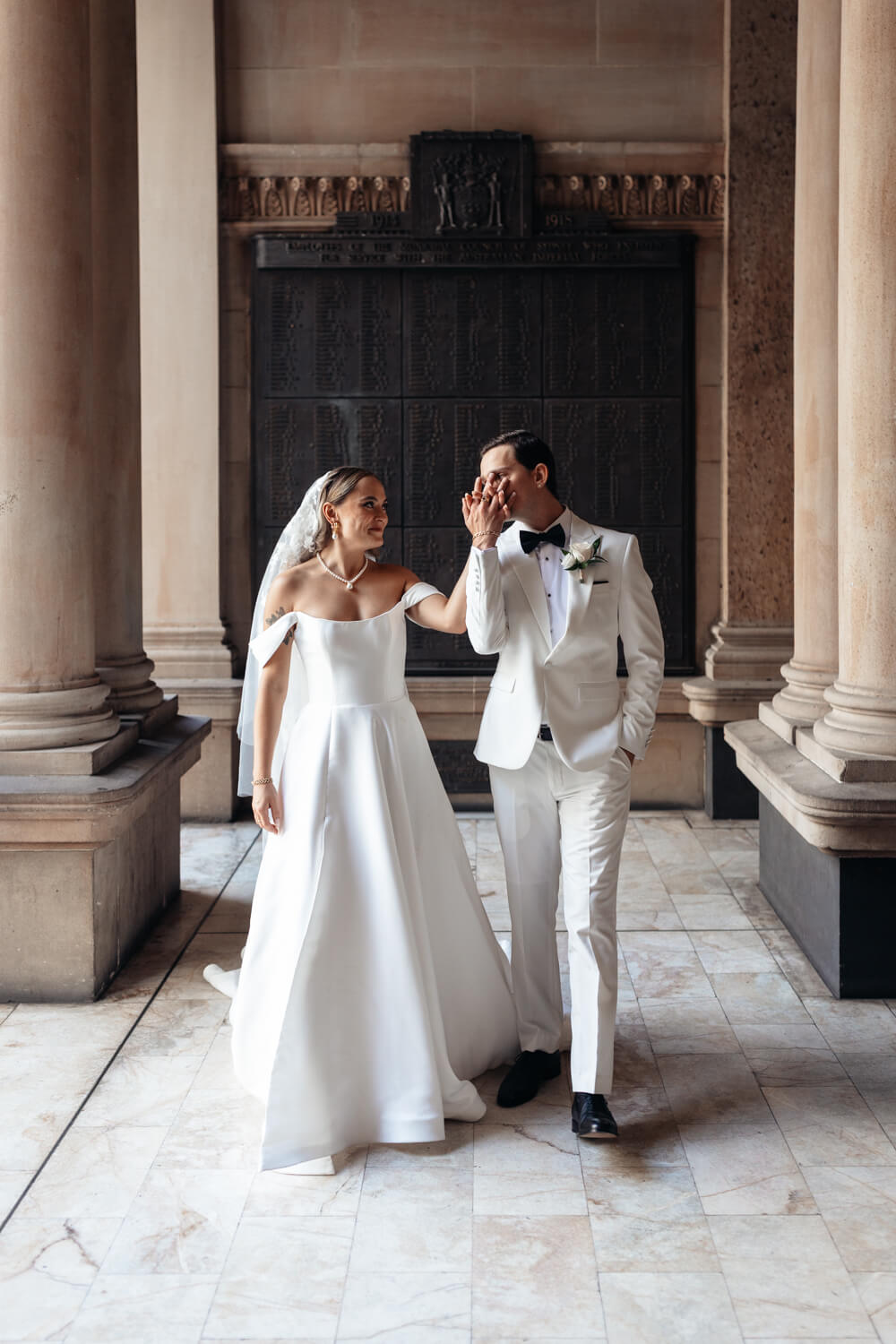 The groom kisses his brides hand at Town Hall in Sydney