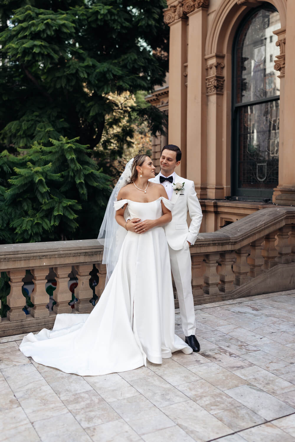 The groom holding his bride outside the Town Hall building in Sydney