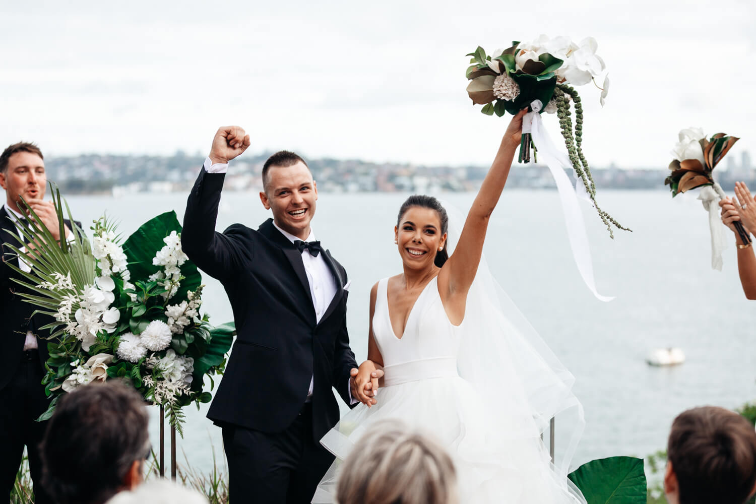 Bride and groom throwing their hands in the air at their Sergeants Mess wedding