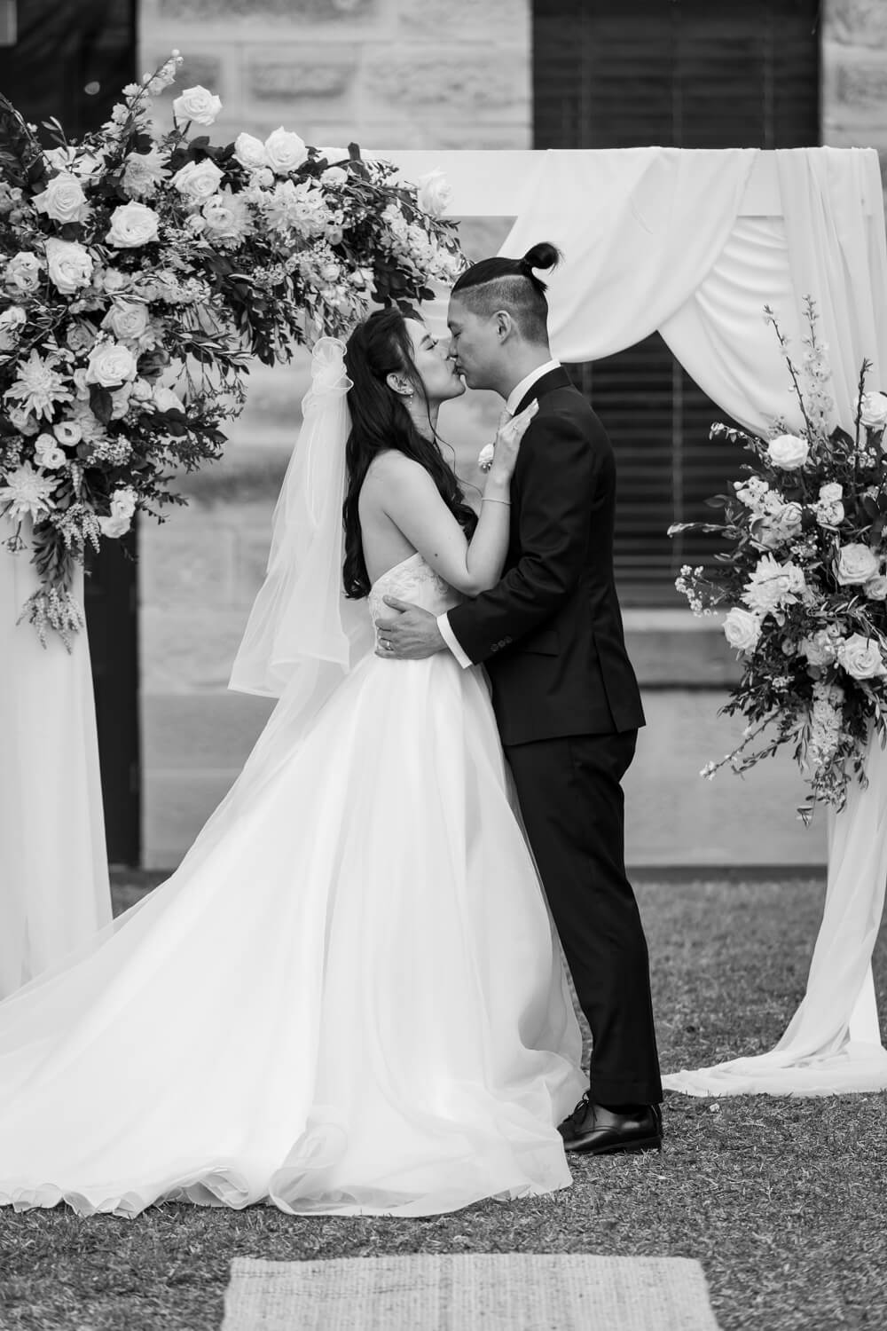 A bride and groom share their first kiss during their ceremony at The Mint