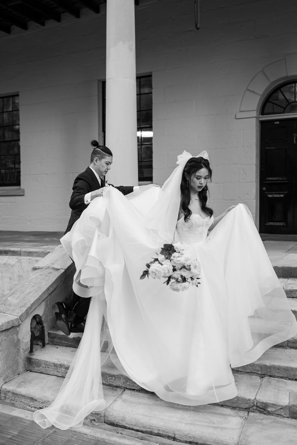 Groom helping his bride during their wedding at The Mint