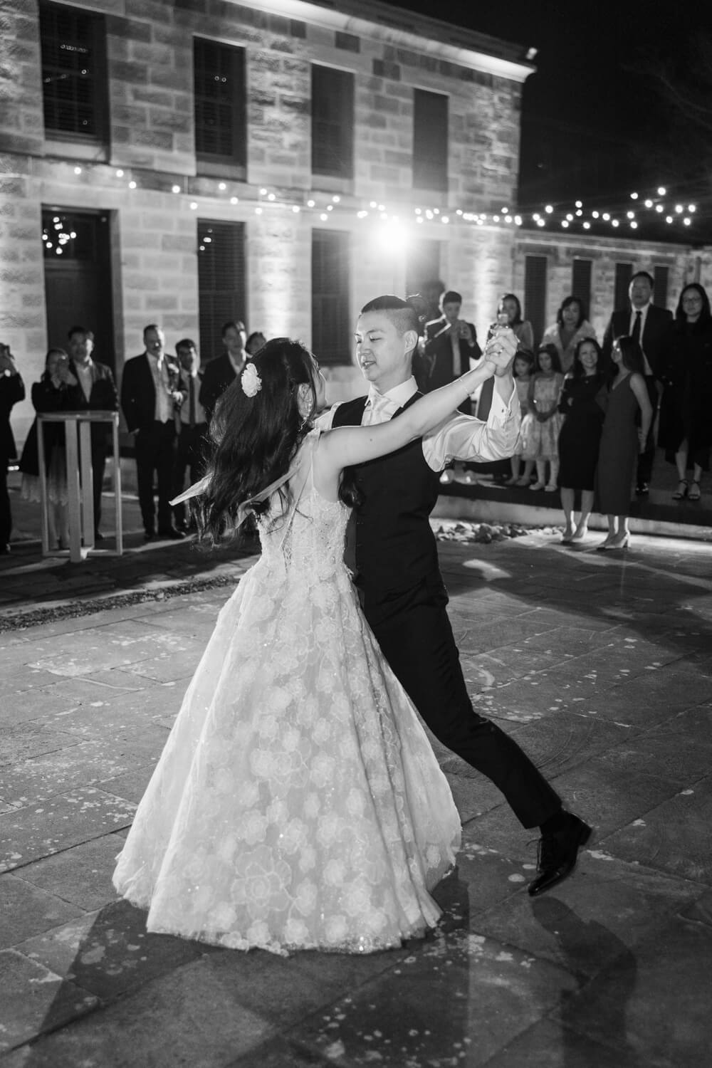 A bride and groom share their first dance in the courtyard at the The Mint in Sydney