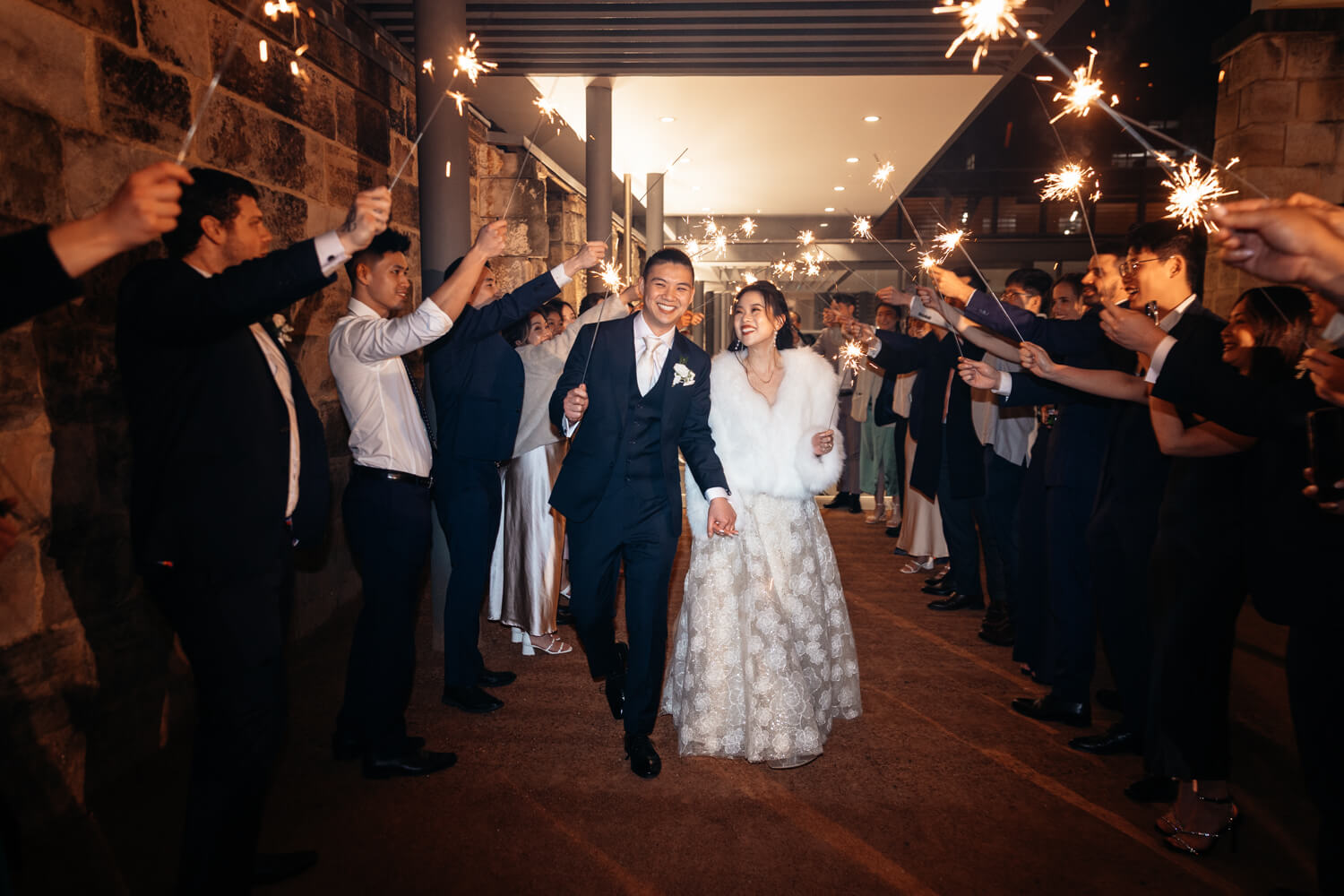 Bride and groom walking through their sparkler exit at the end of their wedding at The Mint 